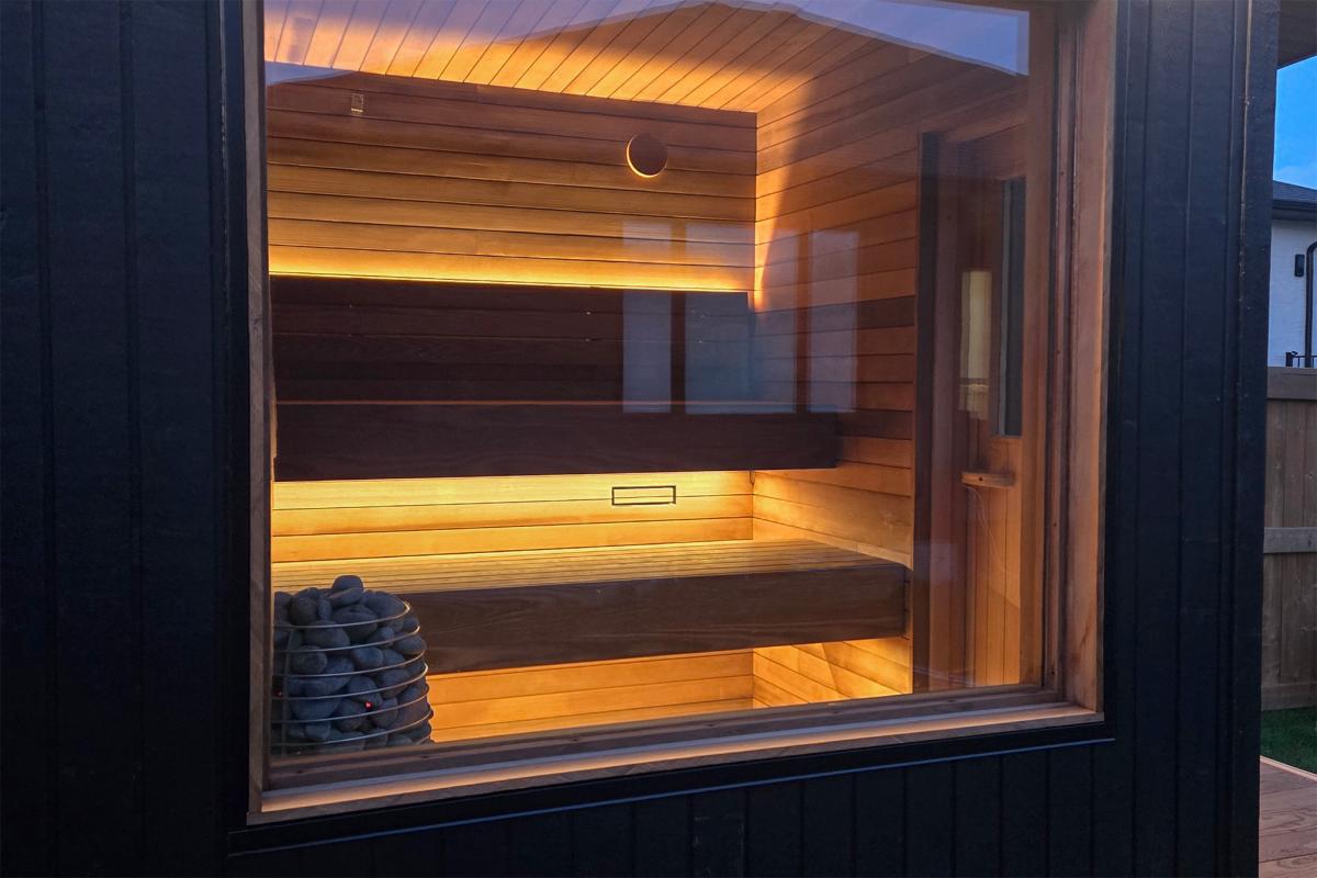 Recessed Ember Cabin window showing wood benches and warm concealed lighting.