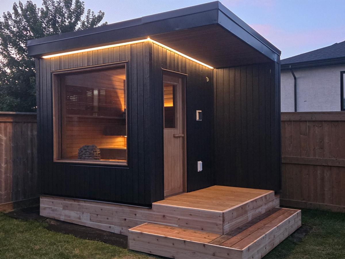 Ember Cabin exterior showing the cedar entrance door, landing, steps and recessed sauna window
