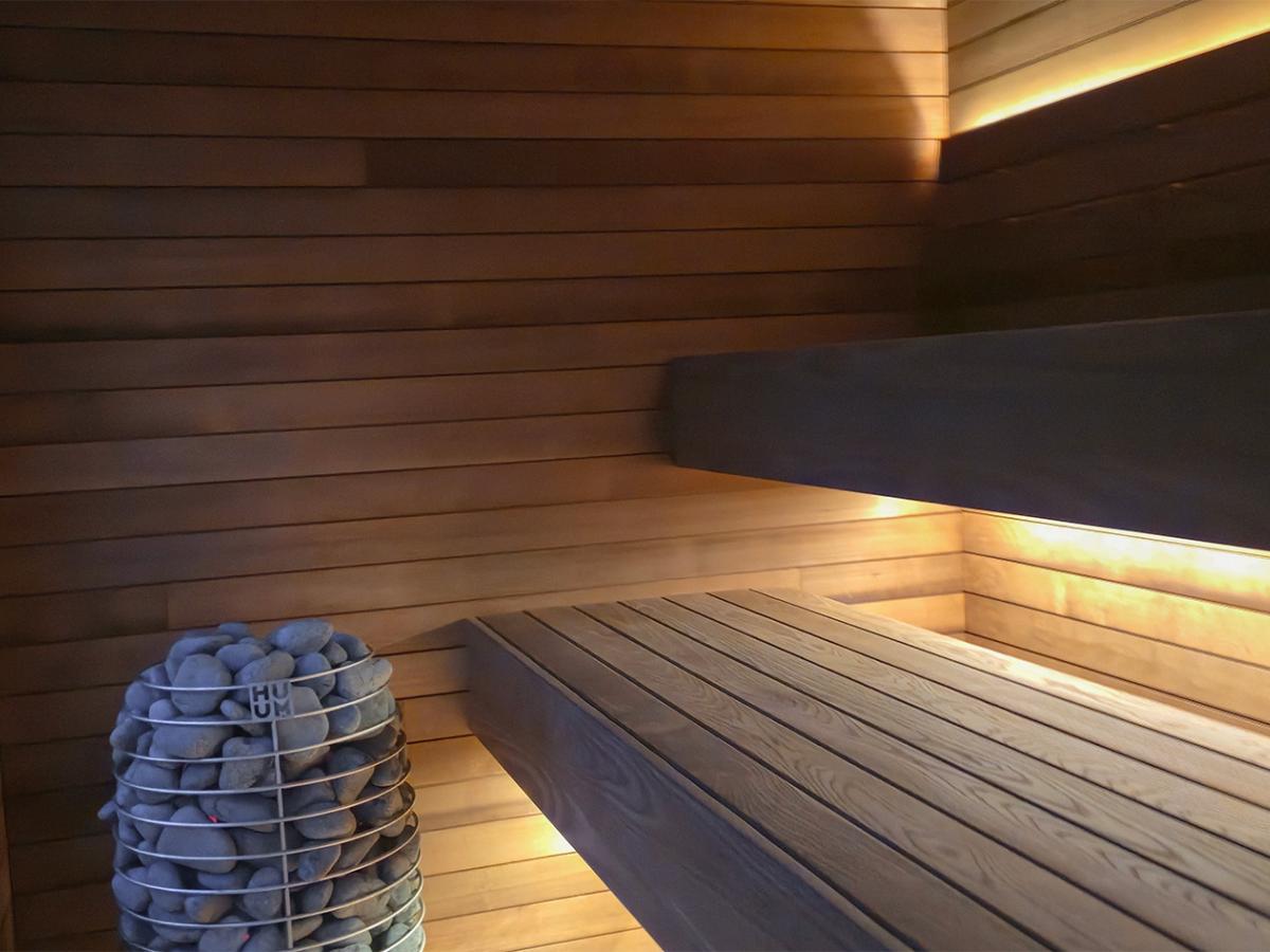 Ember Cabin sauna interior with wood benches, concealed LED lighting and a HUUM electric heater. 