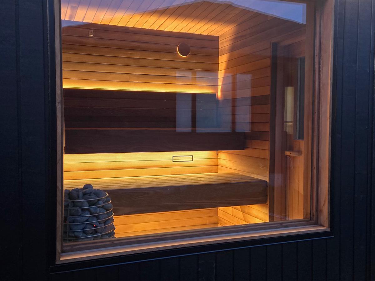 Recessed Ember Cabin window showing wood benches and warm concealed lighting.